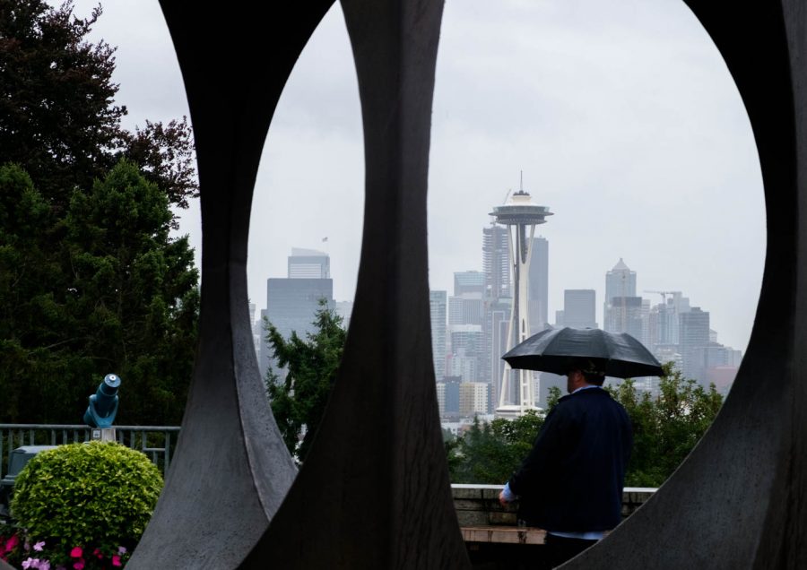 A man walking through Kerry Park is framed by the Changing Form sculpture, with the Space Needle in the background. Blake Dahlin | The Falcon