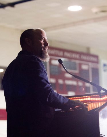 A man standing behind a podium looks to the right.