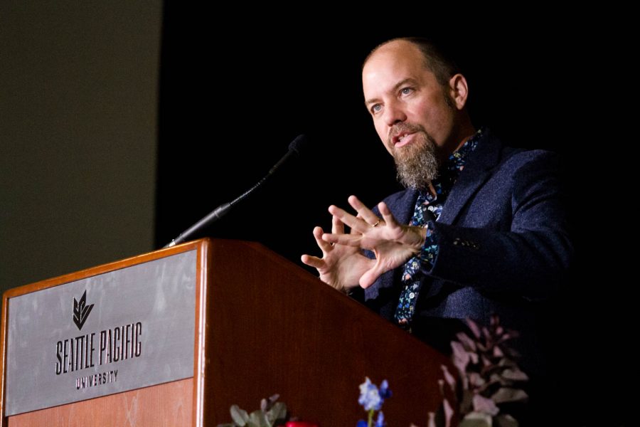 A man gestures with his hands while speaking.