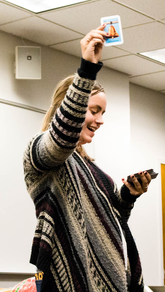 A woman holds a card in the air.