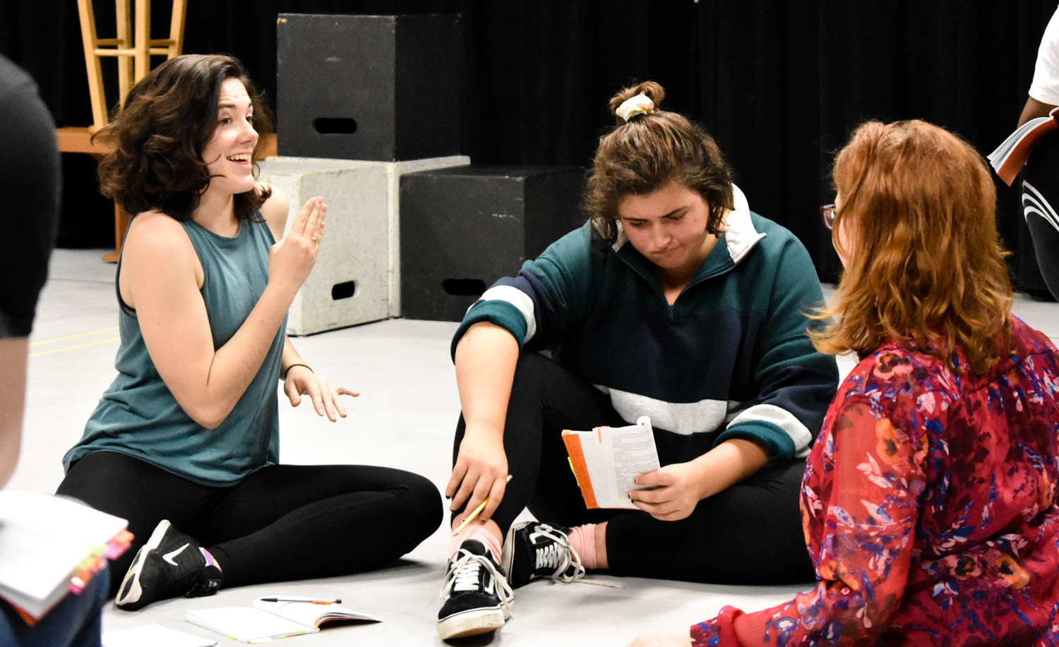 Three women sit in a circle talking.