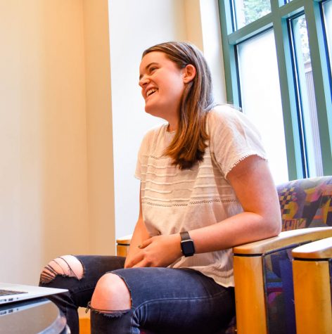 A girl sitting in a chair, smiling.