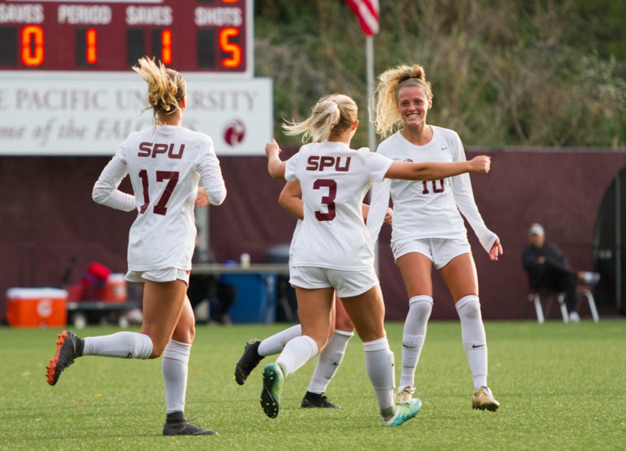 Three players celebrate after scoring a goal