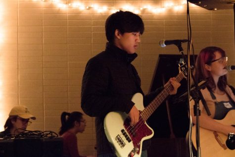 A man strums a bass guitar