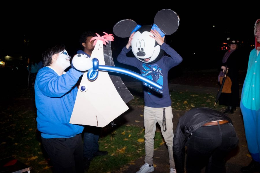 A man in a mickey mouse costume puts his hands on his head