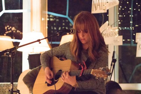 A woman plays a guitar