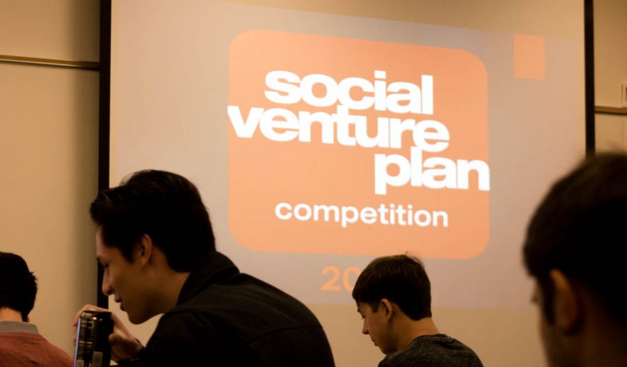 A screen displays a graphic that reads Social Venture Plan Competition