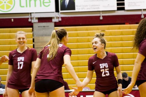 two volleyball players give each other a high five