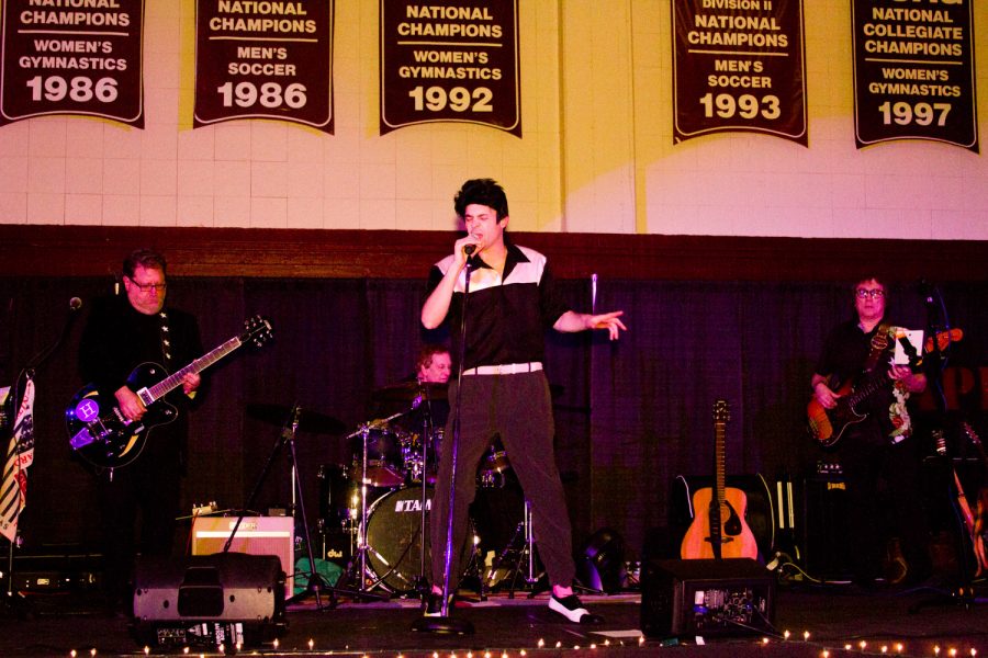 A man dressed as Elvis sings on a stage