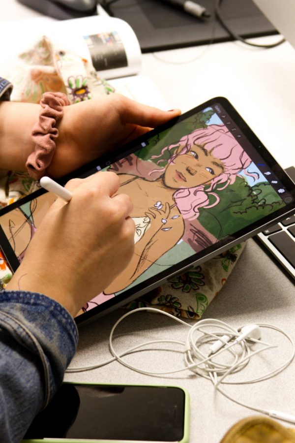 a woman draws on a tablet