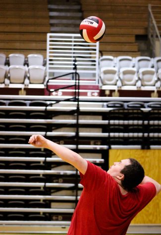 A man jumps to spike a volleyball