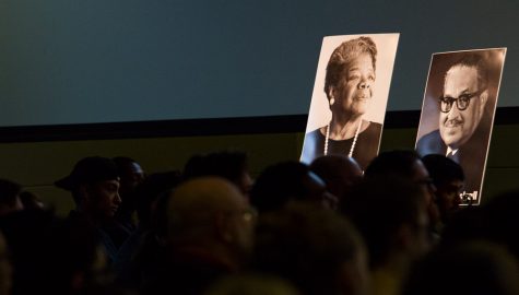 a portrait of a woman on a poster in front of a crowd