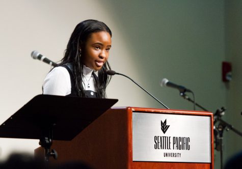 a woman stands behind a podium and speaks