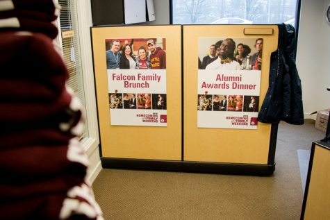 Two posters in an office that read, "Falcon family brunch" and "alumni awards dinner"