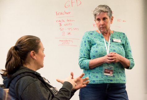 A woman listens to a question from a student