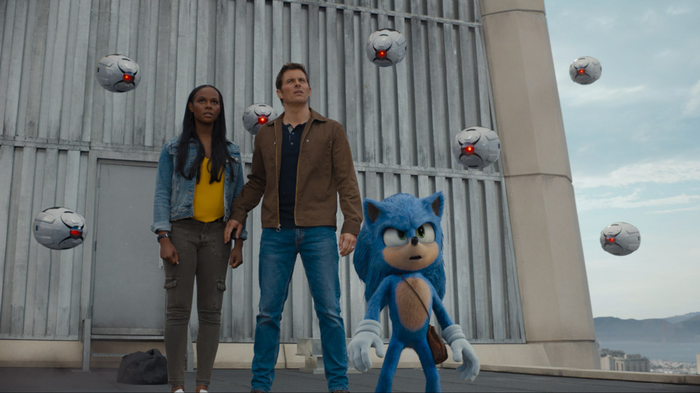 A woman, a man, and an animated sonic the hedgehog stand together