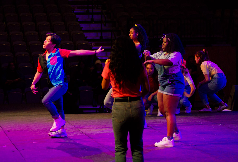 a man stretches his arm back as he performs a dance