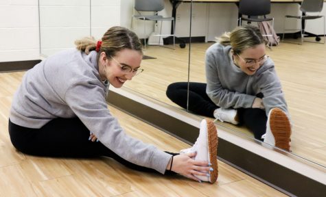 a woman touches her toes and smiles