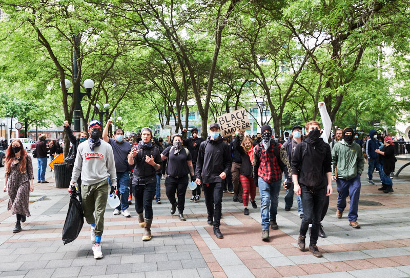 Protestors march through a park