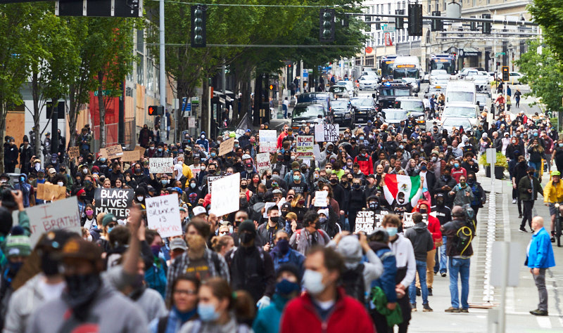 Hundreds of protestors march down a street