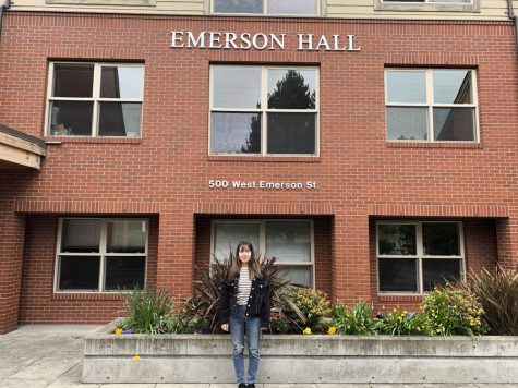 a woman stands in front of a dormitory