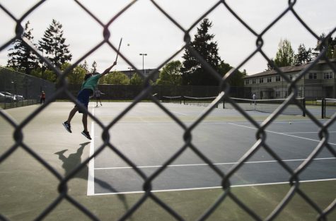 a man jumps and serves in a game of tennis