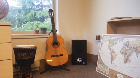 a guitar and two drums in a dorm room