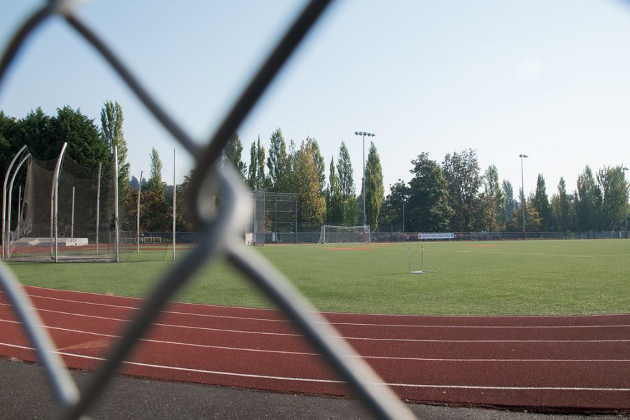 track and field with a chain link fence in front of it