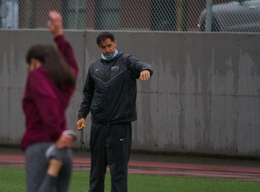 SPU Track and Field Coach Karl Lerum oversees athletes during a practice on Wallace field.