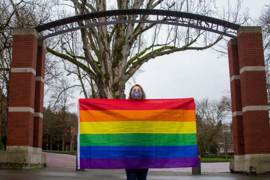 Laurelae Bluntzer holds her flag up with pride in front of the schools arch. She had attended the recent protest against SPUs anti-LGBTQIA+ hiring policies.