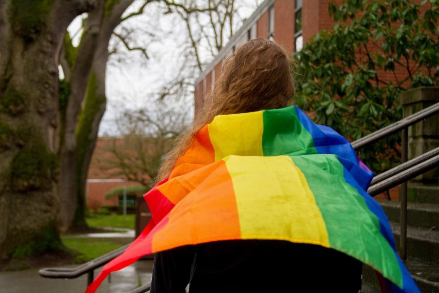 A current student at SPU, Laurelae Bluntzer stands with her LGBTQIA+ flag flowing behind her.