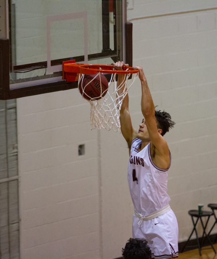 Basketball player dunks ball