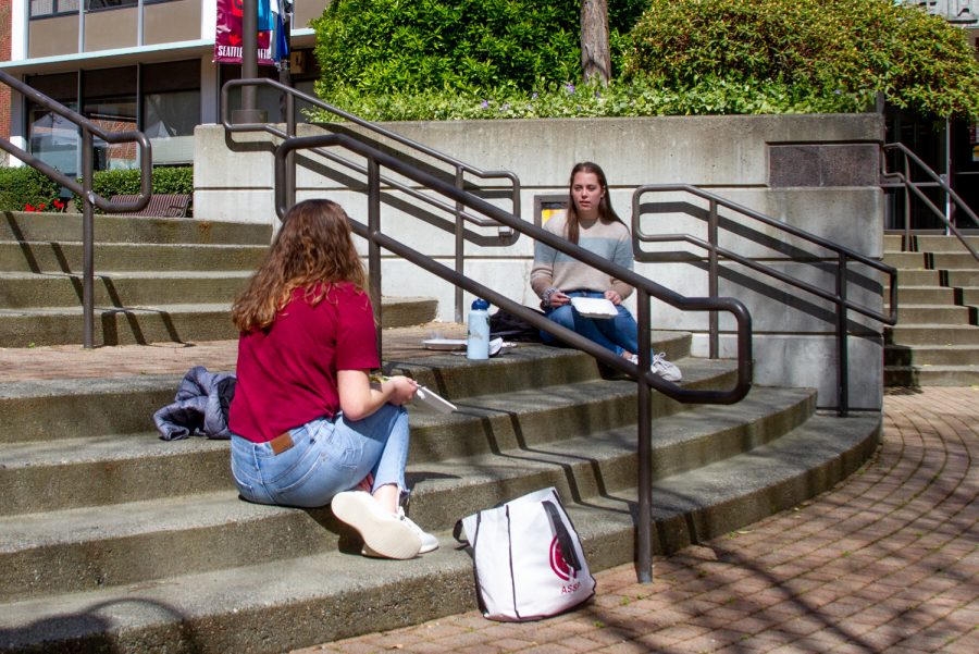 Sitting on the steps of Martin Square is Tenley Nelsen on the left and Haylie Turner to her right, enjoying their lunch outside. They are a couple of many students taking advantage of the warmer weather.