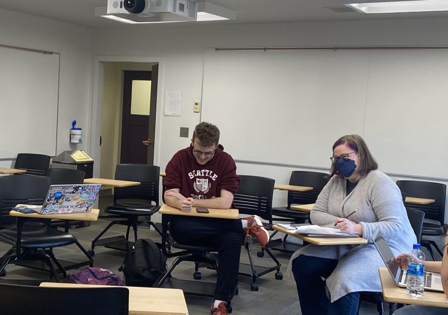 Student Maxwell Hayden and professor Carrie Fry are both seen here sitting without and with a mask on. (Sharli Mishra)