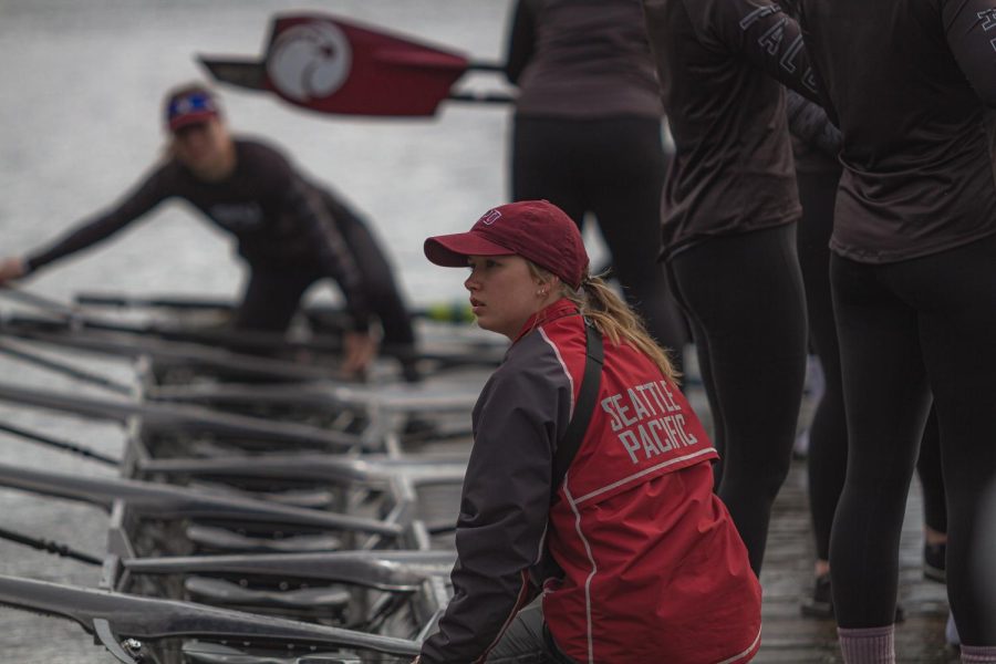 Junior Cox Lucy Sandahl steadies the boat before launch. The rowing team often launches at the canal before dark, prompting concerns about safety.