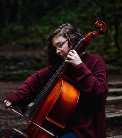 Sarah Ferguson plays the cello in a park. Sarah is in Seattle Pacific orchestra.