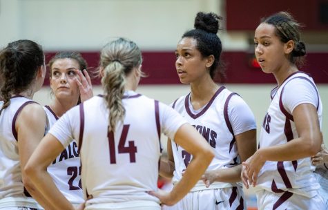 Ashley Alter (left), Natalie Hoff (center), and Maya Hoff (right) talk during a huddle in the second half of the SPU Womens basketball game against Western Oregon on February 4, 2023.