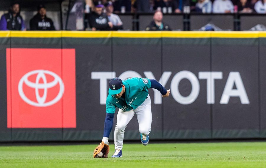 Seattle Mariners left fielder Jarred Kelenic (10) fields a ball during the fourth inning of a baseball game Friday, April 14, 2023, in Seattle. The Mariners won 5-3.