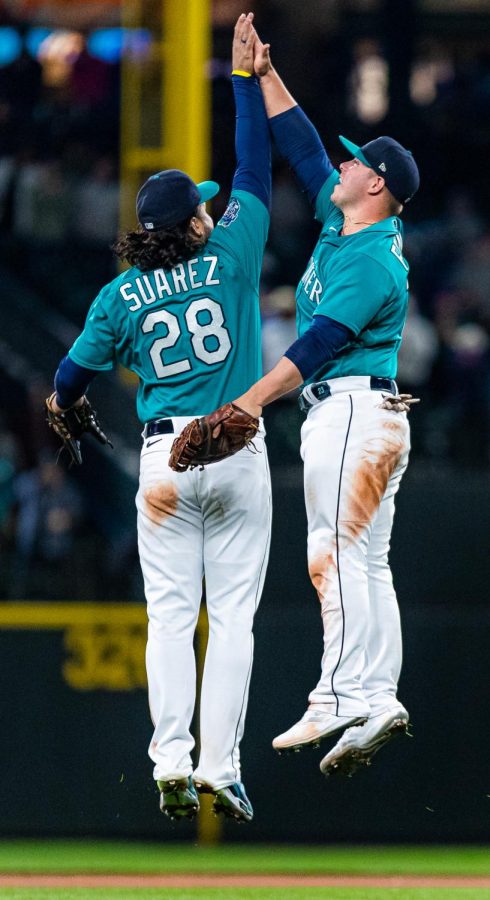 Seattle Mariners third baseman Eugenio Suarez (28) and Seattle Mariners first baseman Ty France (23) high five after a baseball game Friday, April 14, 2023, in Seattle. The Mariners won 5-3.