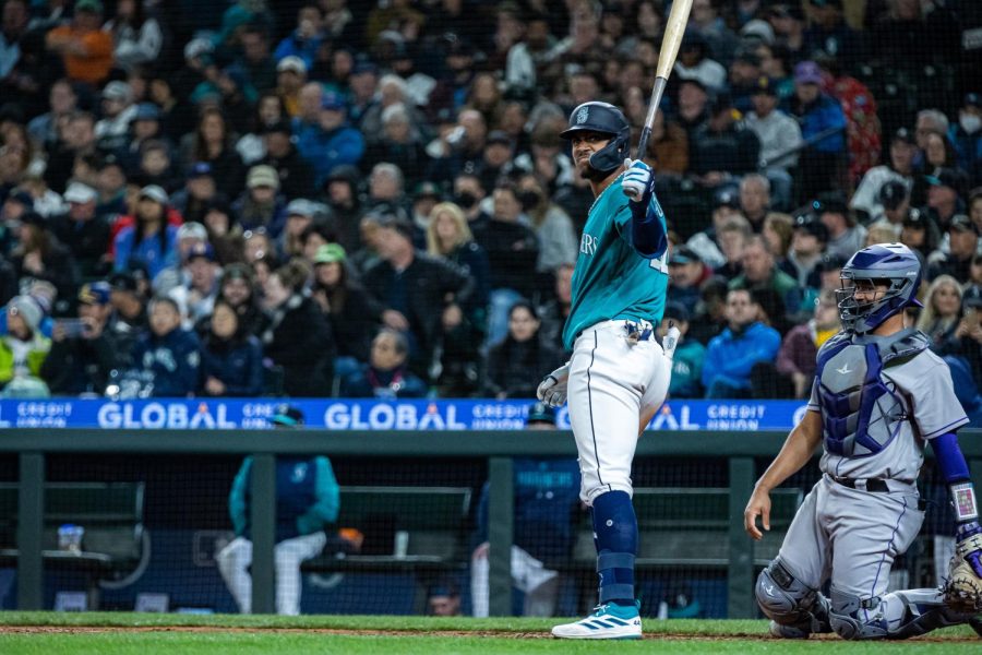 Seattle Mariners center fielder Julio Rodriguez (44) looks back at Seattle Mariners third base coach Manny Acta (14) after taking a pitch during the sixth inning of a baseball game Friday, April 14, 2023, in Seattle. The Mariners won 5-3.