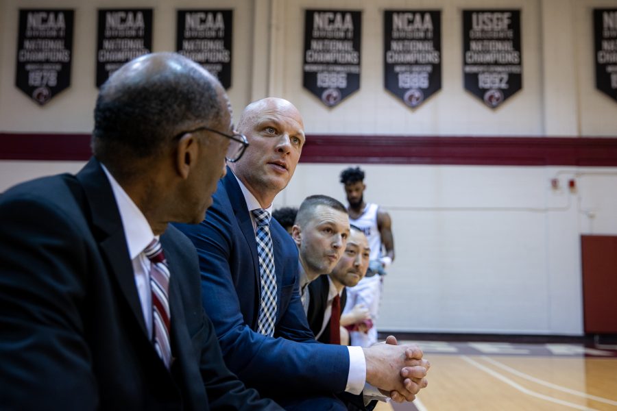 SPU head coach Grant Leep (second from left) looks up at the scoreboard during the the second half of a college basketball game on Saturday, Feb. 25, 2023. Leep will be taking an assistant coach job across town at Seattle U at the end of the year.