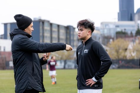 Andrew Tran (right) talks with SPU men’s soccer head coach Kevin Sakuda (left) before a soccer game at Seattle University on Wednesday, April 5, 2023.