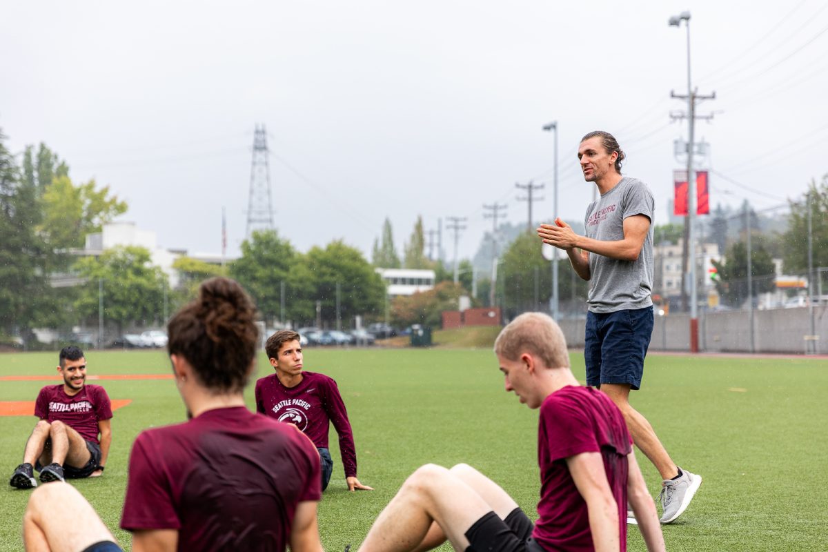 The new Seattle Pacific University Cross Country head coach Eric Hansen addresses his team on Wallace Field during their first practice of the 2023 Season on Tuesday, Aug. 29, 2023.