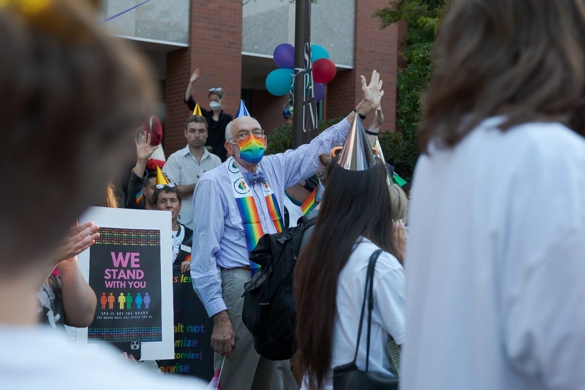 Seattle Pacific University communications professor William Purcell holds up his hand to show support for his students during a demonstration on Monday, Sept. 12, 2022, in Seattle.