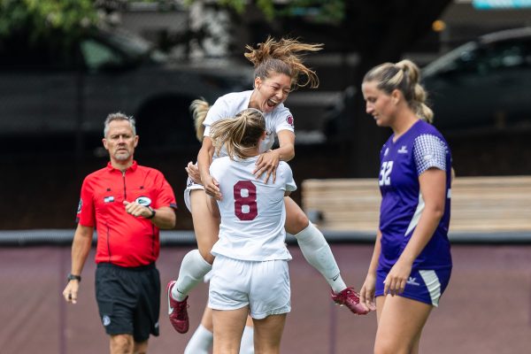 Seattle Pacific University Forward Sophie Beadle (12) jumps on teammate Midfielder Chloe Gellhaus (8) after Gellhaus scored during the second half of a NCAA D2 soccer match on Thursday, Aug. 31, 2023 in Seattle. SPU won 3-2.