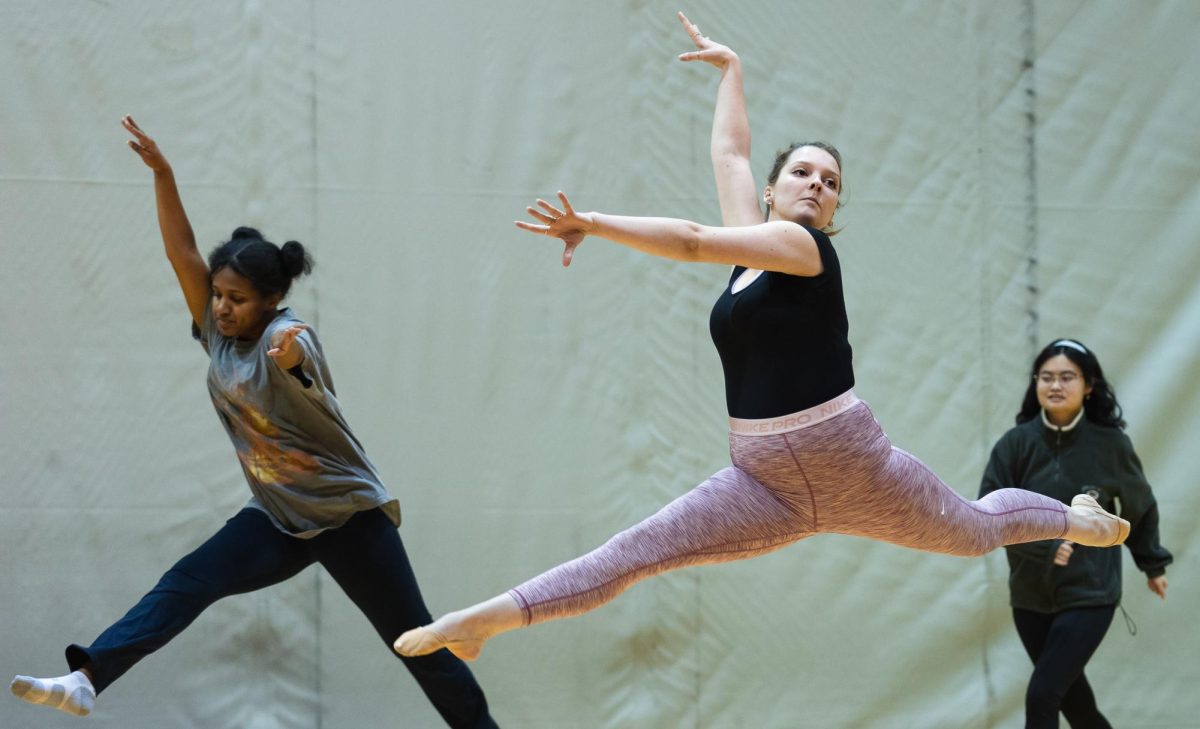 Lia Werner (center) and Ruth Addisu (left) perform a jump during class in Royal Brougham Pavilion on Wednesday, Oct. 18, 2023, in Seattle. Introduction to Ballet, taught by Professor Donna Isobel, is offered in the autumn and spring quarter and meets Mondays and Wednesdays from 9:30-10:20 a.m.