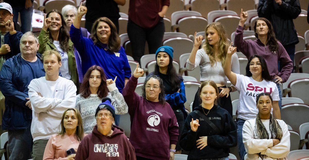 Fans hold their pinkies to the sky before the last point of the set during a NCAA volleyball game between the Seattle Pacific University Falcons and the Northwest Nazarene Nighthawks on Thursday, Sept. 23, 2023.