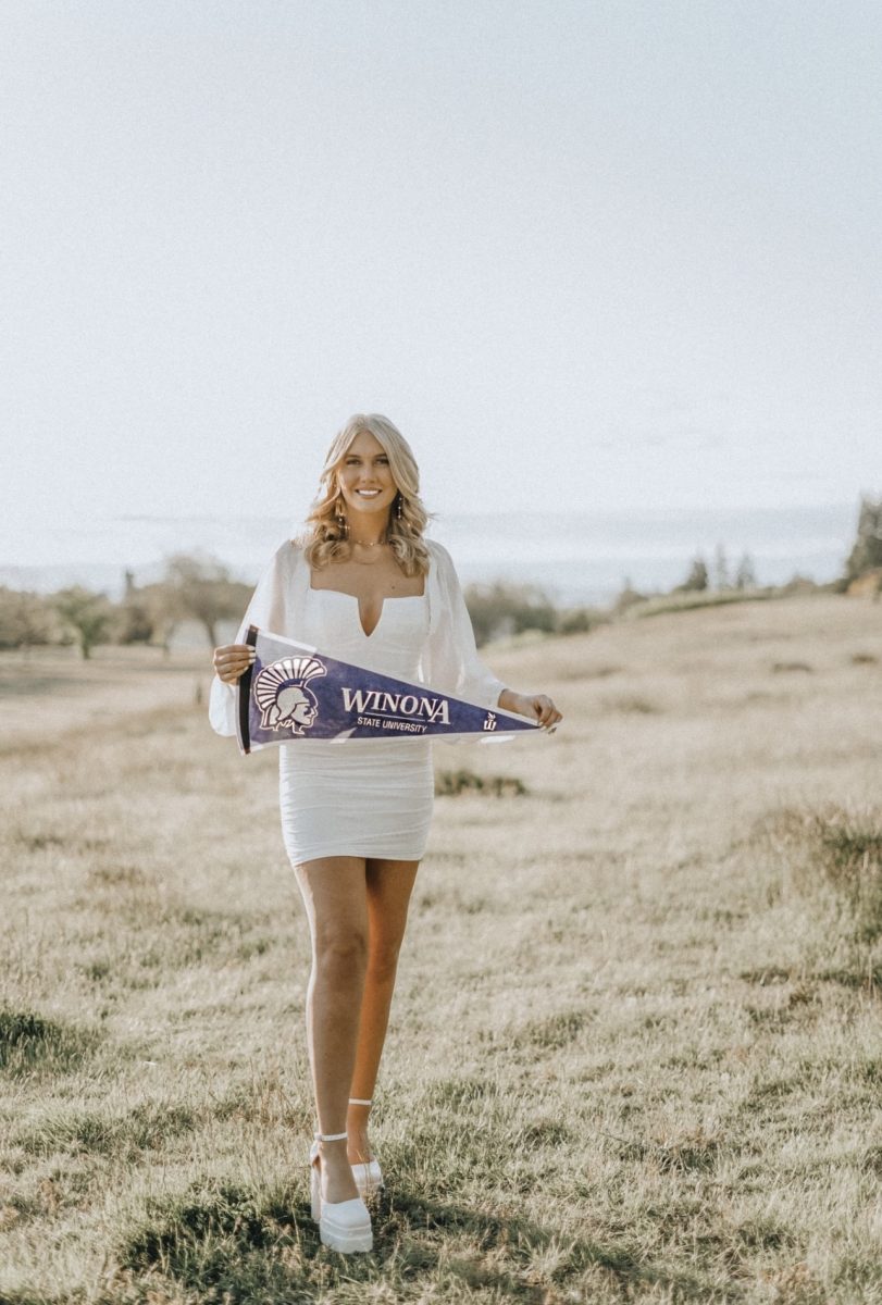 Seattle Pacific University alumnus Kilee Jones, holding up banner for Winona State University, the university she now attends while pursuing a masters degree. (Courtesy of Kilee Jones)