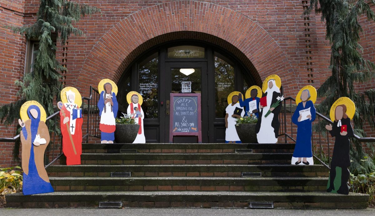 Cut outs of different Saints sit in front of Alexander and Adelaide Hall on Tuesday, Oct. 31, 2023 in Seattle. 