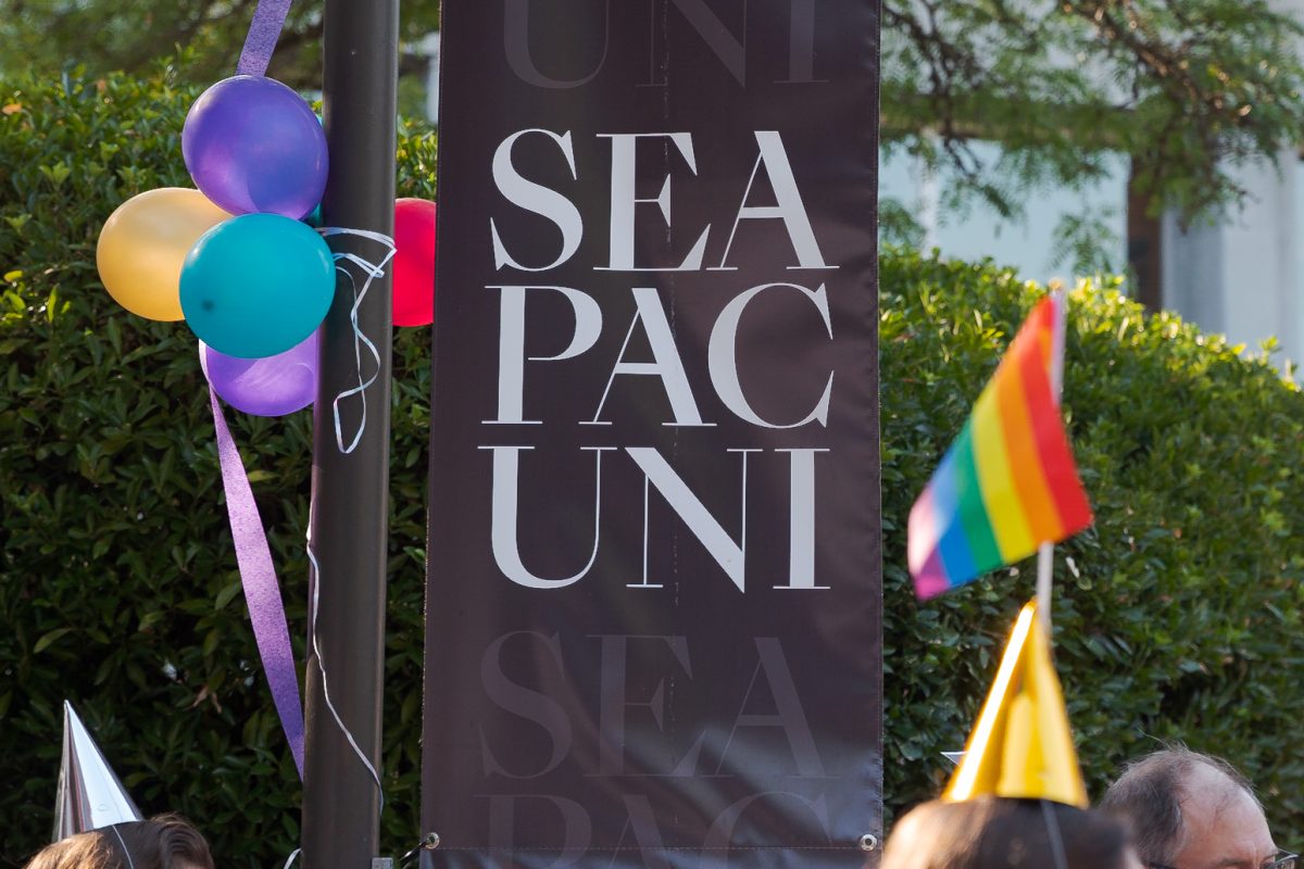A pride flag can be seen next to a Seattle Pacific University Banner during a demonstration in Martin Square on Monday, Sept. 12, 2023 in Seattle. FILE PHOTO